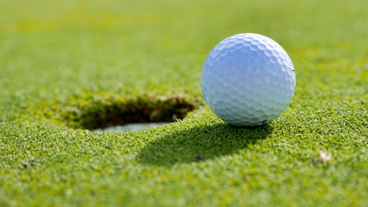 En golfboll som rullar ner i ett av hålen på The Open.